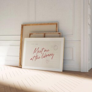Framed "Meet me at the library" artwork.