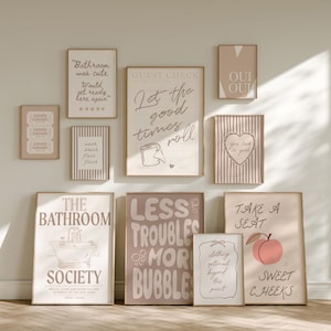 May include: A collection of ten rectangular wall art prints in neutral beige and brown tones. The prints feature various bathroom-themed typography and illustrations, including phrases like Let the good times roll, The Bathroom Society, and Take a seat.