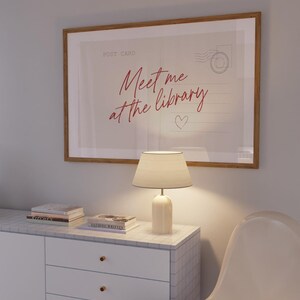 Framed "Meet me at the library" artwork.