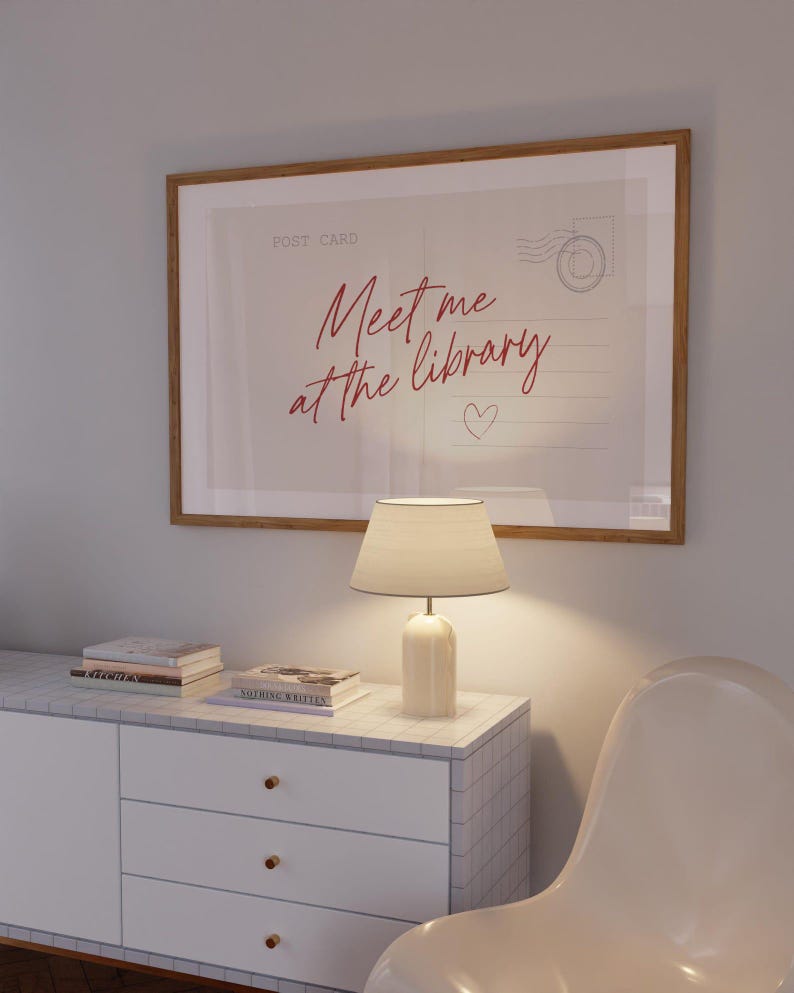 Framed "Meet me at the library" artwork.