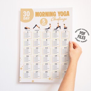 Hand holding a printable morning yoga challenge.