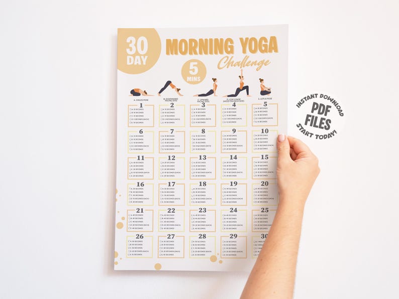 Hand holding a printable morning yoga challenge.