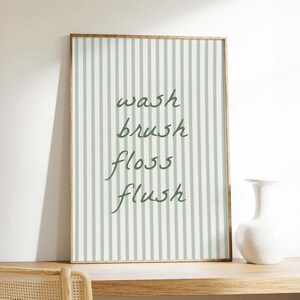 A printable striped "wash brush floss flush" sign, styled as trendy aesthetic bathroom decor.
