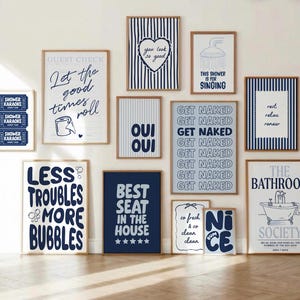 Puede incluir: Un conjunto de pared de galería con once láminas enmarcadas que presentan tipografía e ilustraciones en azul marino y blanco. Los diseños incluyen frases como Let the good times roll, Get Naked y The Bathroom Society, con gráficos de baño.