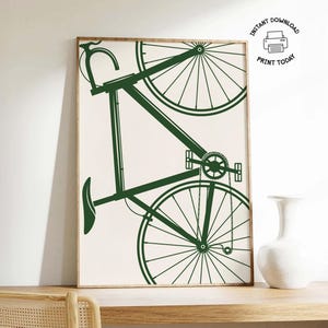 May include: A framed print featuring a dark green bicycle illustration against a cream background. The bicycle is depicted in a minimalist style, with the wheels, frame, and pedals clearly visible. The print includes the text "INSTANT DOWNLOAD PRINT TODAY".