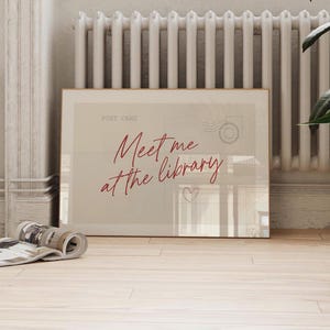 Framed "Meet me at the library" artwork.