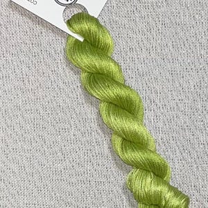 May include: A skein of bright green cotton embroidery floss. The floss is twisted and has a tag that reads "Dyeing for Cross Stitch" and "Hand Dyed Fabric and Floss". The tag also includes a website address.