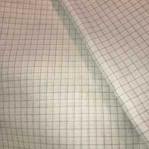 May include: A close-up of a light beige fabric with a subtle grid pattern. The fabric is woven with a fine texture and has a slightly rough feel.