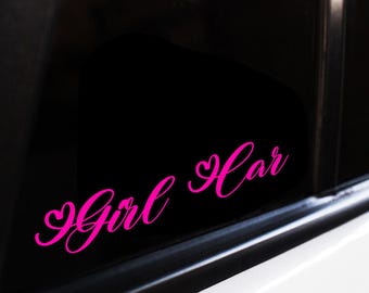 Peut inclure: Autocollant de voiture rose avec l'inscription "Girl Car" en écriture cursive. Le mot "Girl" est précédé d'un cœur, et "Car" est suivi d'un cœur. L'autocollant est sur une vitre de voiture.