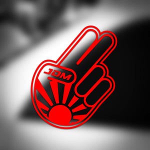 May include: A red and black graphic of a hand forming a peace sign, with the letters "JDM" at the top. The design incorporates a rising sun motif at the base, set against a blurred black and white backdrop.