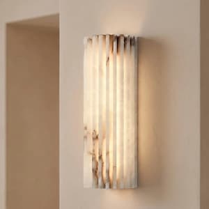 Könnte beinhalten: Rechteckige Wandleuchte mit vertikalem, geripptem Design. Die Leuchte besteht aus einem durchscheinenden, cremefarbenen Material mit braunen Maserungen. Das Licht scheint durch das gerippte Design und erzeugt ein warmes Leuchten.