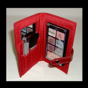 Puede incluir: Estuche de maquillaje de cuero rojo con un espejo y una pequeña paleta de sombras de ojos. La paleta tiene seis tonos: Silversmoke, Pink Chiffon, Smoky Bronze, Bubbles, Silver Lilac y Twilight. El estuche también incluye tres pinceles.