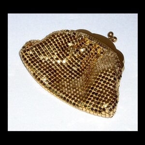 May include: A gold mesh coin purse with a clasp closure.