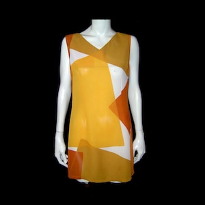 May include: A sleeveless, V-neck dress in shades of yellow, orange, and white. The dress features a geometric pattern of overlapping shapes. The garment is displayed on a white mannequin against a black background.
