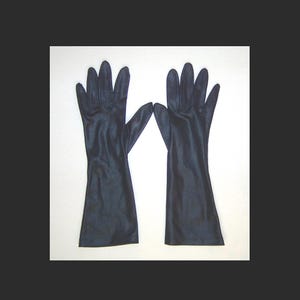 Könnte beinhalten: Ein Paar lange, schwarze Handschuhe. Die Handschuhe bestehen aus einem glatten, glänzenden Material und reichen über das Handgelenk hinaus. Die Finger sind vollständig geformt und die Handschuhe werden vor einem weißen Hintergrund präsentiert.