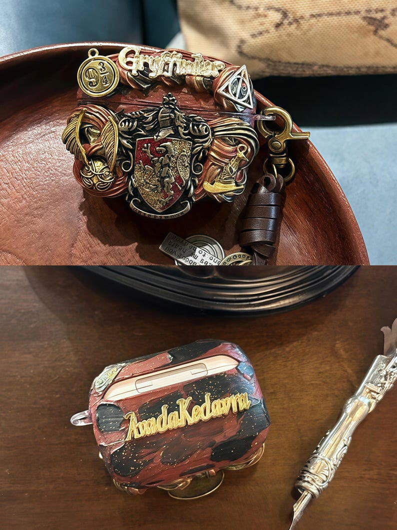 May include: Two Airpod cases, one with a red, gold, and black design with the words "Avada Kedavra" and the other with a red, gold, and brown design with the words "Gryffindor" and a Hogwarts crest.