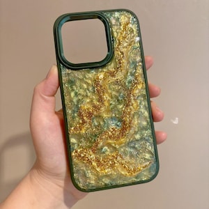May include: A green and gold phone case with a glittery, marbled design.