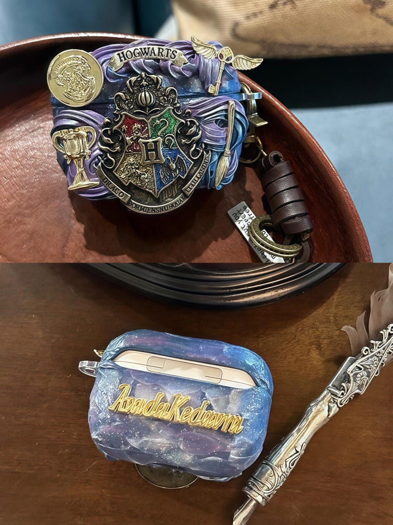 May include: Two Airpod cases. One is a blue and purple case with a galaxy design and the text "Avada Kedavra" in gold. The other is a purple and blue case with the Hogwarts crest and the text "Hogwarts" in gold.