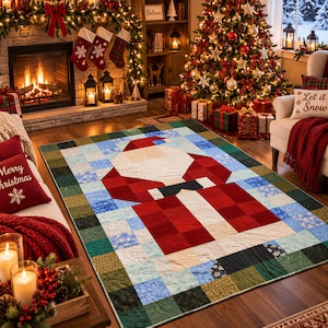 Puede incluir: Una colcha rectangular con un diseño geométrico pixelado de Santa Claus en rojo, blanco y negro. La figura central está rodeada por un borde de pequeños cuadrados multicolores en tonos azules, verdes y blancos con patrones de copos de nieve.