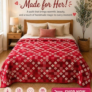 May include: A red and white quilt with a geometric pattern covers a bed. The quilt features a patchwork design with squares and floral accents. The text "Stitched with Love, Made for Her!" is at the top. The image also includes the text "Shop Now, Make Her Day Special!"