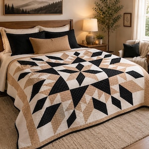 May include: A quilt featuring a geometric star pattern in a color palette of black, cream, and tan. The design consists of repeating diamond and triangular shapes arranged in a large central star motif with a border of matching patterned fabric.