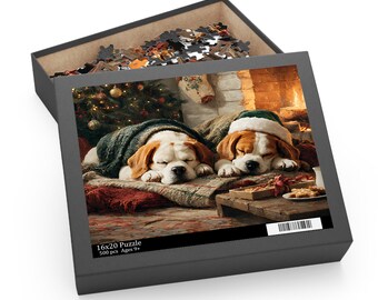 May include: A 500-piece 16x20 puzzle in a black box featuring an illustration of two brown and white dogs sleeping under blankets near a Christmas tree and fireplace. The box lid displays the text 16x20 Puzzle, 500 pcs, and Ages 9+.