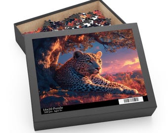 May include: A 500-piece jigsaw puzzle in a black box featuring a leopard resting under a tree at sunset. The box lid displays the image and text 16x20 Puzzle, 500 pcs, Ages 9+. Loose puzzle pieces are visible inside the open cardboard container.