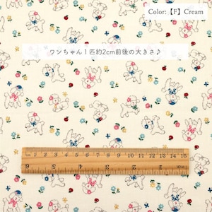 May include: Cream-colored fabric with a repeating pattern of cartoon poodles, flowers, and small red berries. The poodles are approximately 0.8 inches in size. The fabric also features text in Japanese.