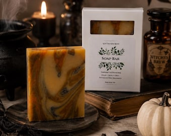 May include: A rectangular soap bar with a marbled orange, yellow, and black pattern stands on a dark plate next to its white box. The box label reads LOVE THE REIKI ROOM, SOAP BAR, Traditional Cold Process Soap, Vegan, Cruelty Free, Phthalate-Free Fragrance.