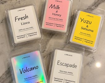 May include: Five rectangular clear plastic containers of soy wax melts from LTRR & CO. The labels feature scents including Fresh Linen, Milk & Honey, Yuzu & Satsuma, Volcano with a holographic finish, and Escapade, all marked as hand poured.