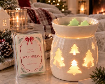 May include: A white ceramic wax warmer with cut-out pine tree shapes and a light green wax melt inside, next to a clear plastic package of wax melts labeled Love the Reiki Room Wax Melts Happy Holidays with a red bow and pine branch graphics.