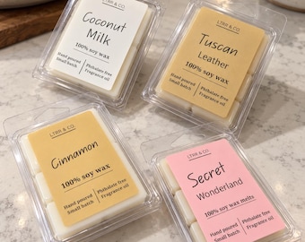 May include: Four clear plastic clamshell containers filled with white soy wax melts. Each package features a label with the brand LTRR & CO. and scent names: Coconut Milk, Tuscan Leather, Cinnamon, and Secret Wonderland, noting 100% soy wax.
