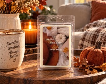 May include: A clear plastic clamshell container holding wax melts with a label featuring a white pumpkin, a brown hat, and autumn leaves. The text on the label reads Love The Reiki Room Wax Melts. The container is rectangular with a hanging tab at the top.