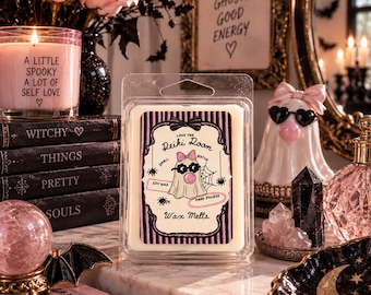 May include: A clear plastic clamshell package containing white wax melts. The label features a pink and black striped border, a ghost illustration with a pink bow and sunglasses blowing a bubble, and text reading Love the Reiki Room Wax Melts.