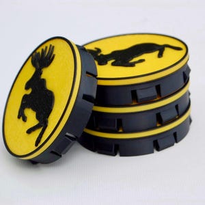 Peut inclure: Ensemble de dessous de verre noirs et jaunes avec une silhouette noire d'animal sautant sur fond jaune. Les dessous de verre ronds ont un bord rainuré. Image sur fond blanc.