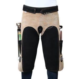 May include: A tan leather blacksmith apron with black leather knee pads and tool pockets. The apron has a black leather belt with the text "Farrier Tools" in orange.