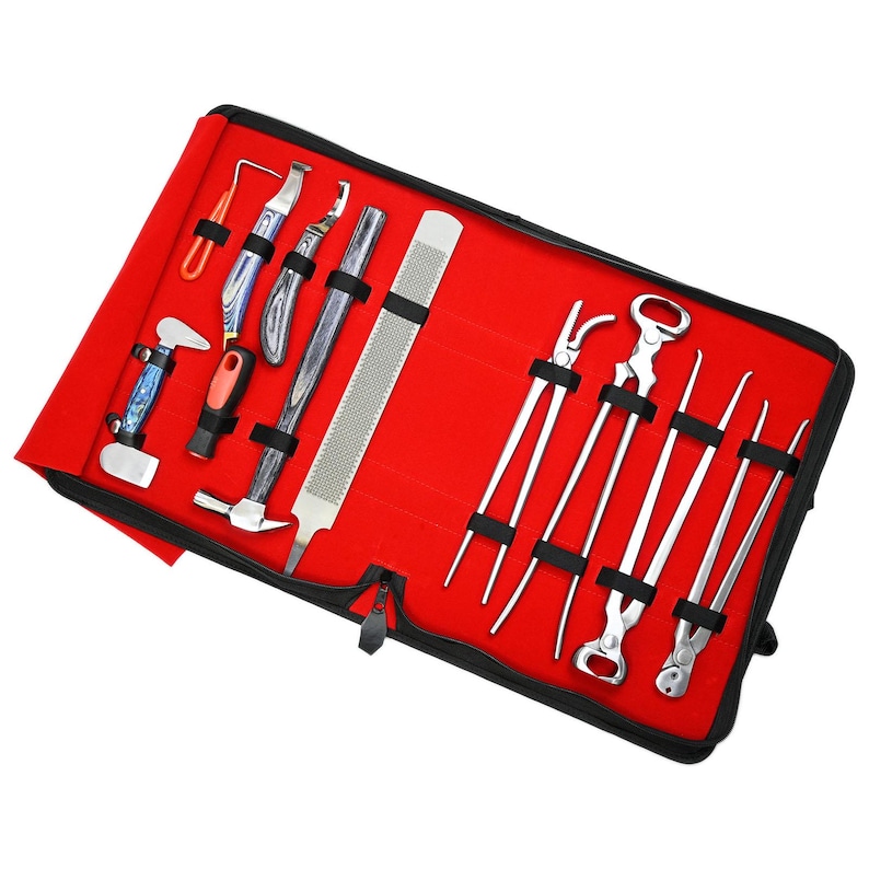 May include: A red tool roll with a variety of metal farrier tools. The tools include hoof knives, a rasp, nippers, and a hammer. The tools are secured in black elastic straps. The roll is open and the tools are visible.