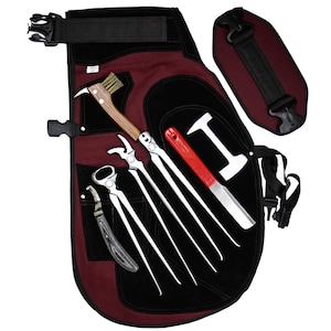 May include: A burgundy farrier apron with black accents and multiple pockets, holding various metal tools with wooden and red handles. Includes a hoof knife, nippers, and a hammer.