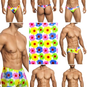 Op de afbeelding: Een collectie zwemkleding met een levendig bloemenpatroon van felgele, roze, blauwe en groene madeliefachtige bloemen op een witte achtergrond. De set bevat verschillende stijlen zoals slips, zwembroeken en shorts met dezelfde print.