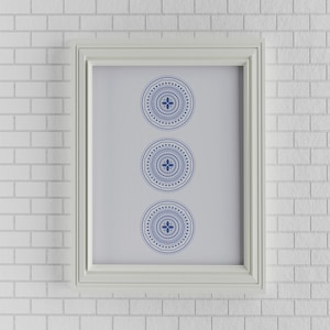 May include: A white framed picture with three blue and white patterned circles on a white brick wall background.