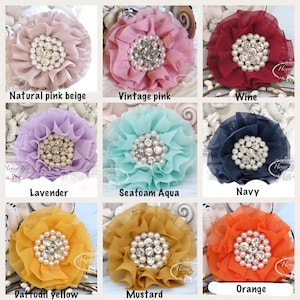 May include: A collection of handmade fabric flowers in various colors, including natural pink beige, vintage pink, wine, lavender, seafoam aqua, navy, daffodil yellow, mustard, and orange. Each flower features a pearl and rhinestone center. Text on the image reads "Natural pink beige", "Vintage pink", "Wine", "Lavender", "Seafoam Aqua", "Navy", "Daffodil yellow", "Mustard", and "Orange".