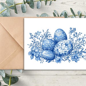 May include: Blue and white patterned Easter eggs surrounded by delicate white flowers and blue leaves.