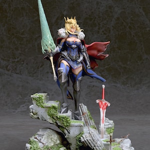 May include: A detailed figurine of a female character with blonde hair, wearing a blue and gold armor, a red cape, and a crown. She is holding a long, green spear and standing on a rocky base with a red sword and other details.