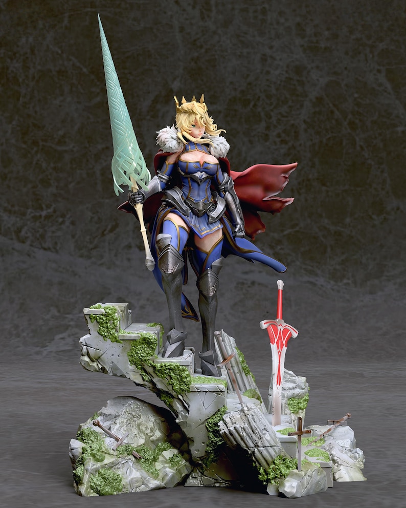 May include: A detailed figurine of a female character with blonde hair, wearing a blue and gold armor, a red cape, and a crown. She is holding a long, green spear and standing on a rocky base with a red sword and other details.
