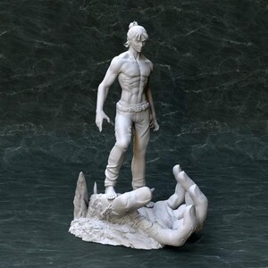 K&ouml;nnte beinhalten: Eine wei&szlig; bemalte Figur eines Mannes, der auf einer gro&szlig;en Hand steht. Der Mann tr&auml;gt eine Hose und hat einen Pferdeschwanz. Die Hand ist Teil einer gr&ouml;&szlig;eren Skulptur.