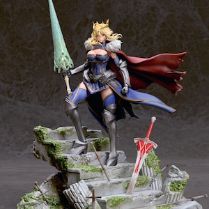 May include: A detailed figurine of a female warrior in a blue and gold armor, holding a green spear and standing on a stone platform with a red sword lying on the steps. The warrior has blonde hair and a crown, and is wearing a red cape.