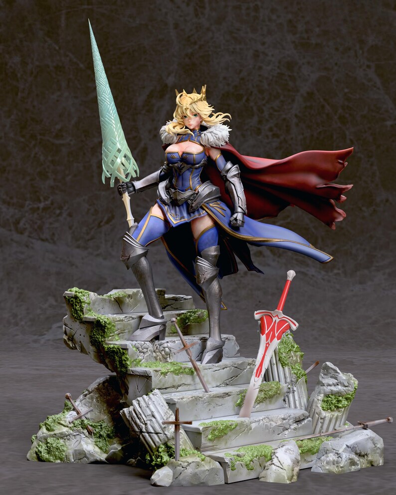 May include: A detailed figurine of a female warrior in a blue and gold armor, holding a green spear and standing on a stone platform with a red sword lying on the steps. The warrior has blonde hair and a crown, and is wearing a red cape.