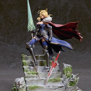 May include: A detailed figurine of a female character in a blue and gold armor, holding a green spear. She is standing on a stone platform with a red sword and a smaller sword. The figurine is set against a dark gray background.