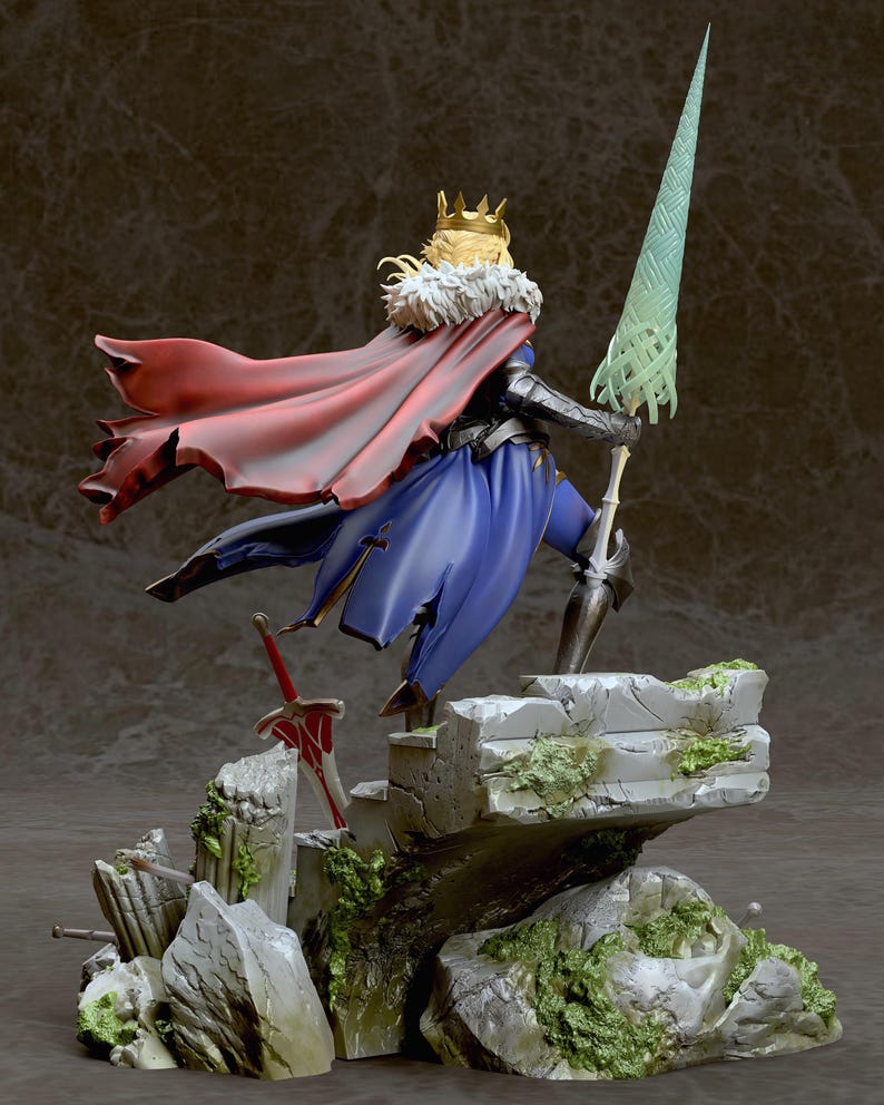 May include: A detailed figure of a fantasy character wearing a blue and red outfit with a gold crown and holding a spear. The figure is standing on a rocky base with green moss.