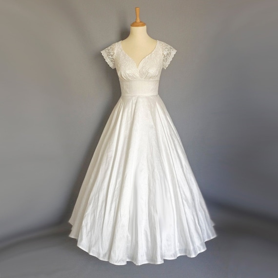 Danielle silk dupioni wedding gown with single dramatic ruched strap  adorned with an Austrian crystal brooch,ruched bodice fits low over the  hips and falls into a full box pleated skirt with a
